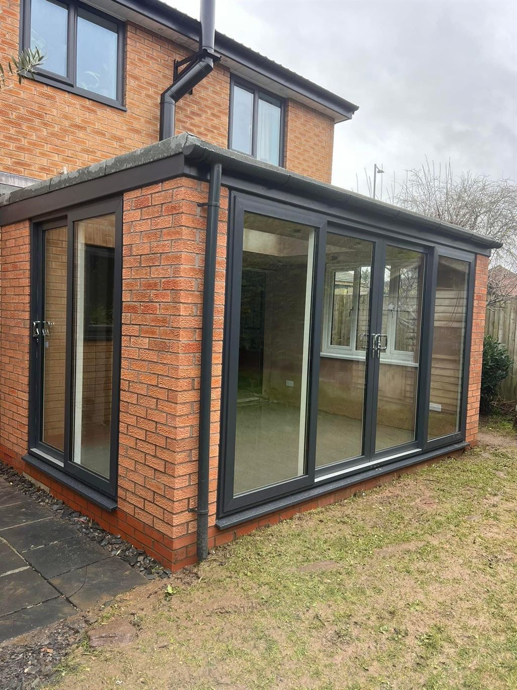 Anthracite orangery with brick base and bi-fold doors